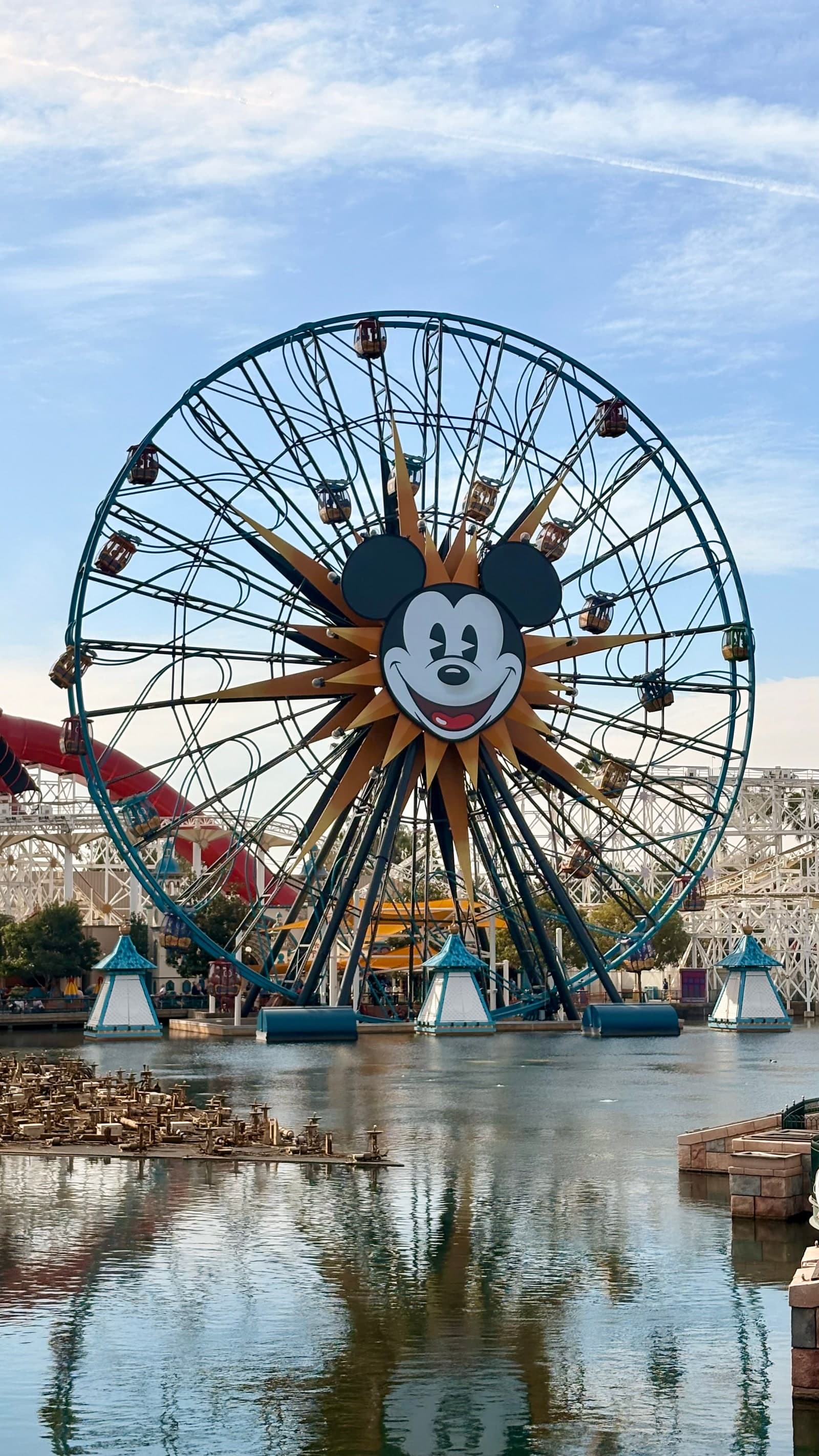 The Mickey-faced Pixar Pal-A-Round wheel reflected in the water at Disney California Adventure.