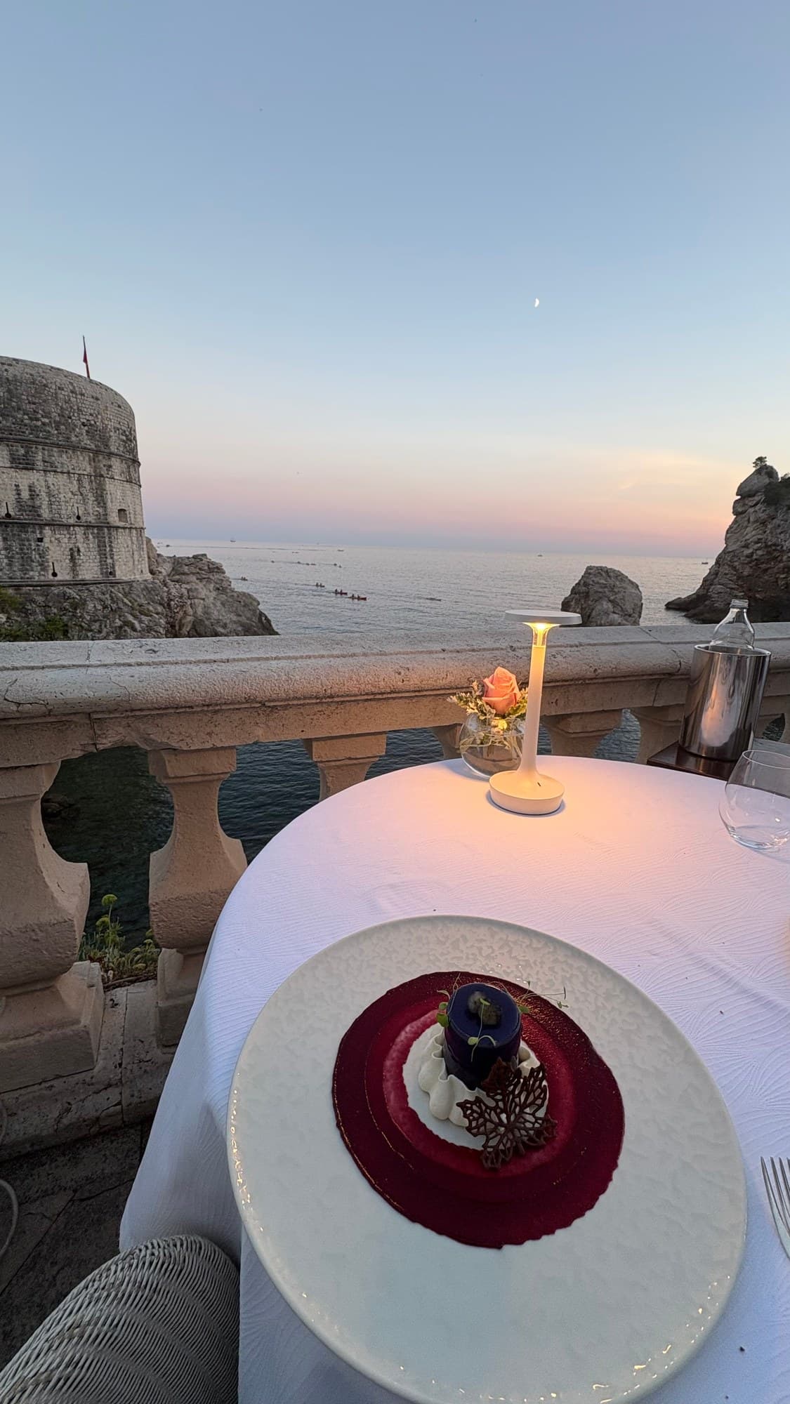 Blueberry dessert on Nautika’s terrace, with the sea and Dubrovnik’s stone fortifications beyond the table.