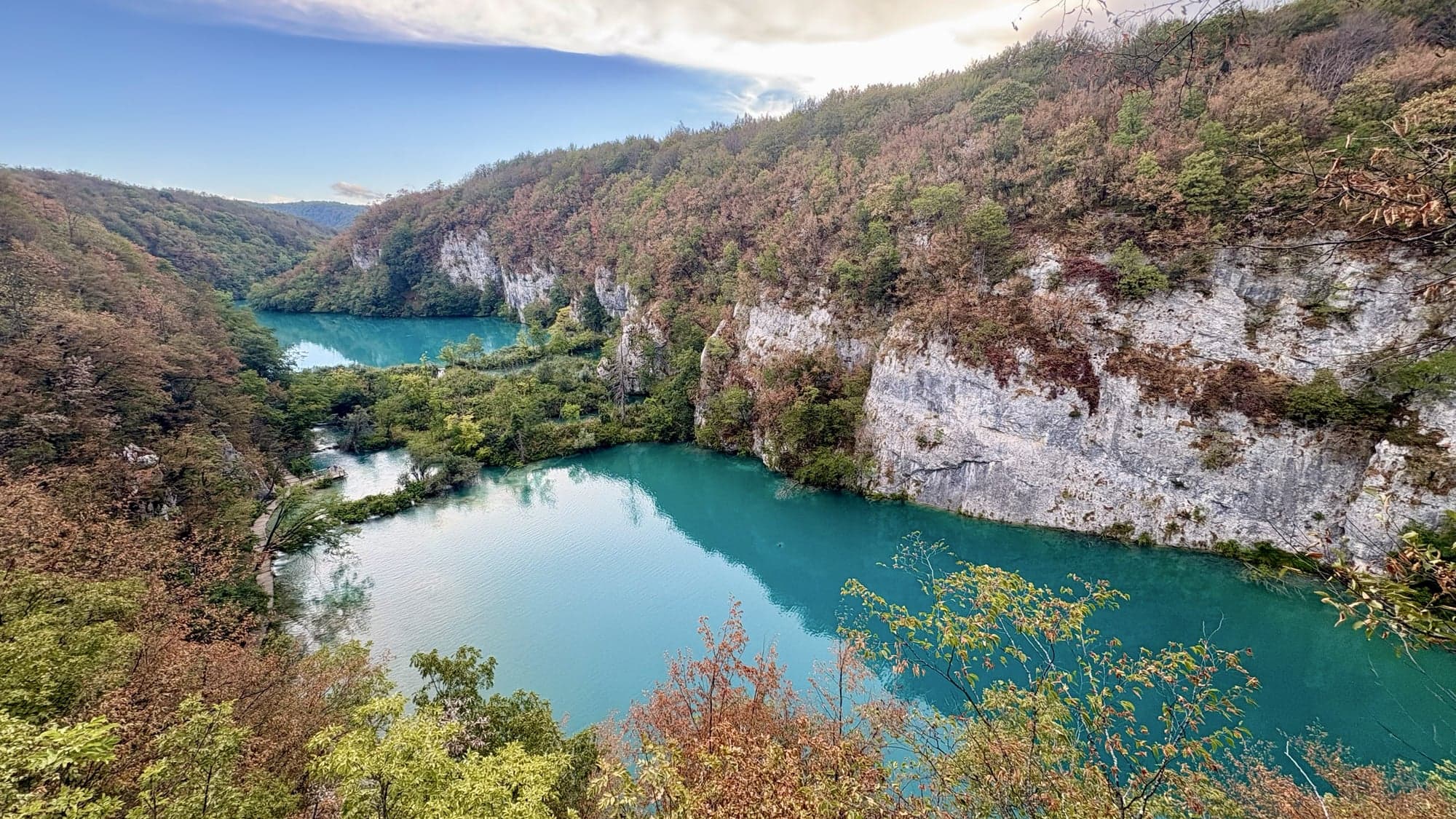 A wide view across the clear lake toward the forest at Plitvice Lakes National Park