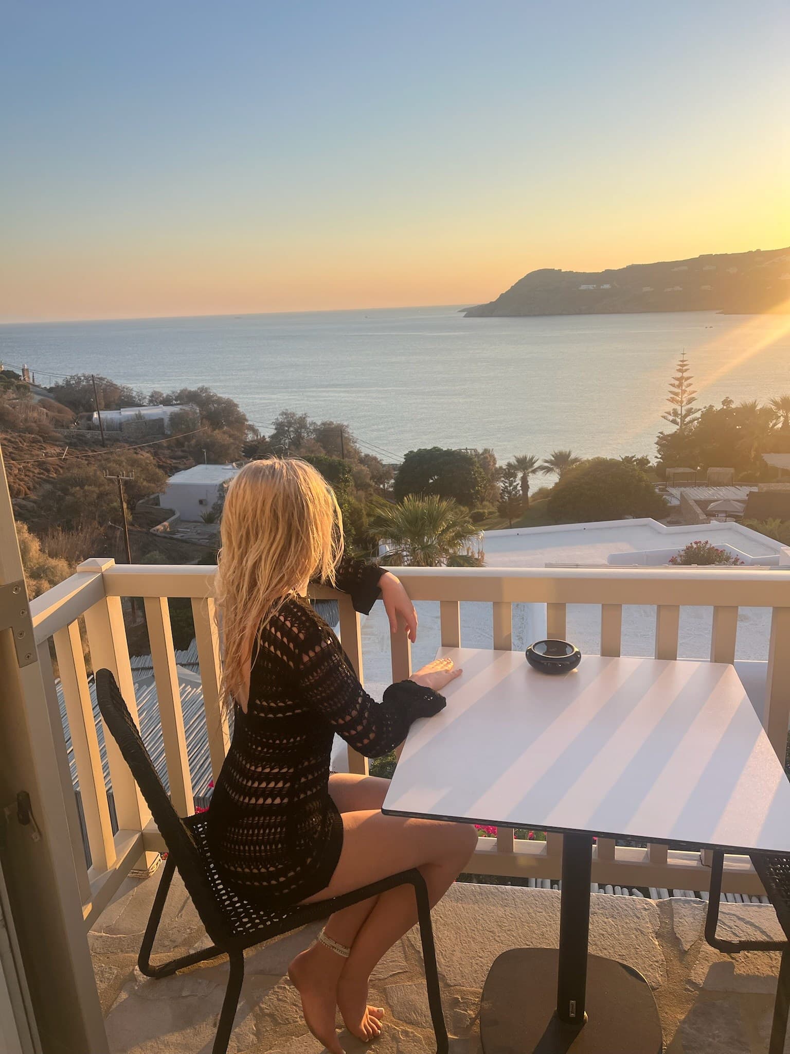 Hannah looking over the sea from a terrace at sunset